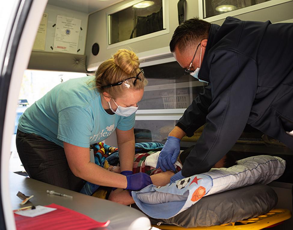 LVN II的香农·梅扎克（Shannon Mezak）的照片，他在医疗运输中帮助疫苗接种了儿科高风险患者杰克·伯兰加（Jake Berlanga）。（摄影：Kim Kham，UT医生）